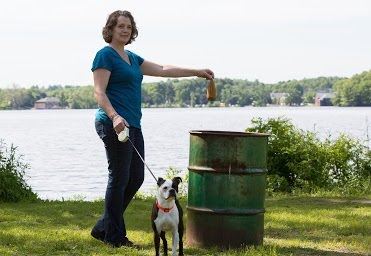 Woman Dropping Dogs Poop Bag in Trash